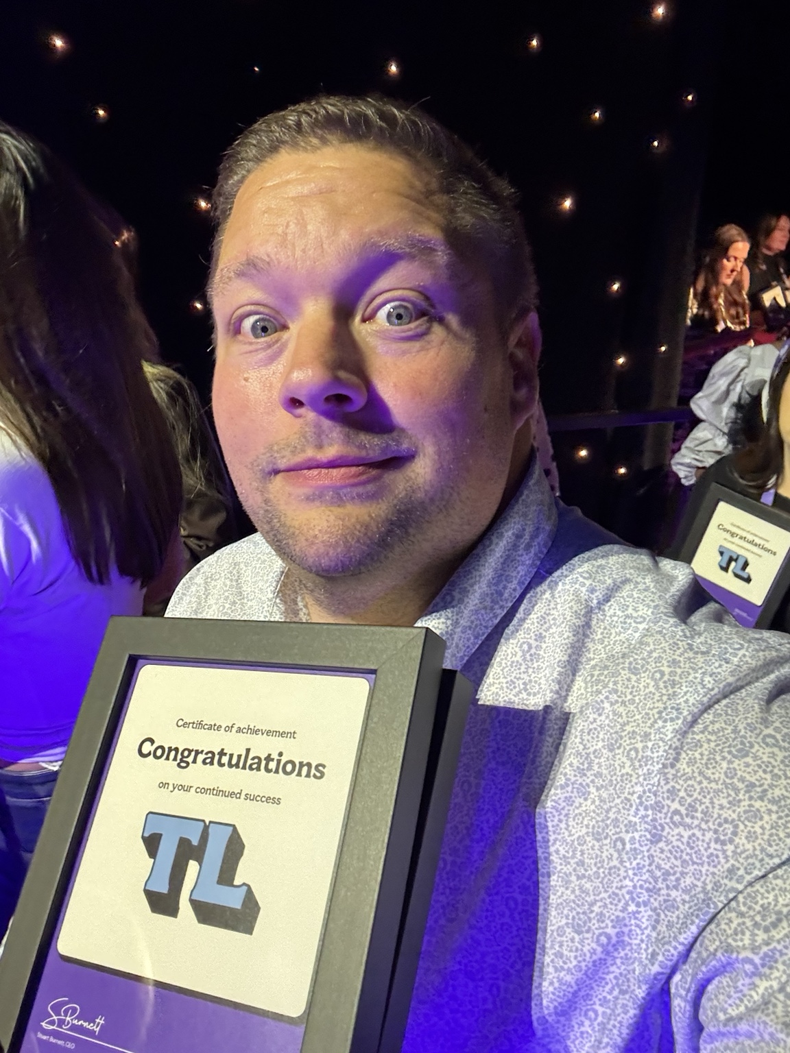 James holding a team leader achievement certificate